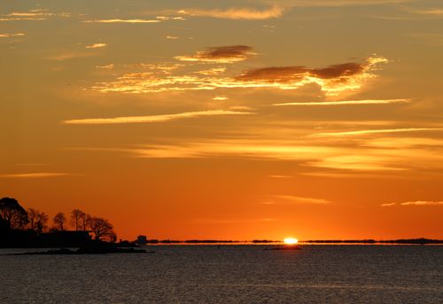 Free A tranquil sunrise illuminates the autumn sky over Stamford's coastal landscape. Stock Photo