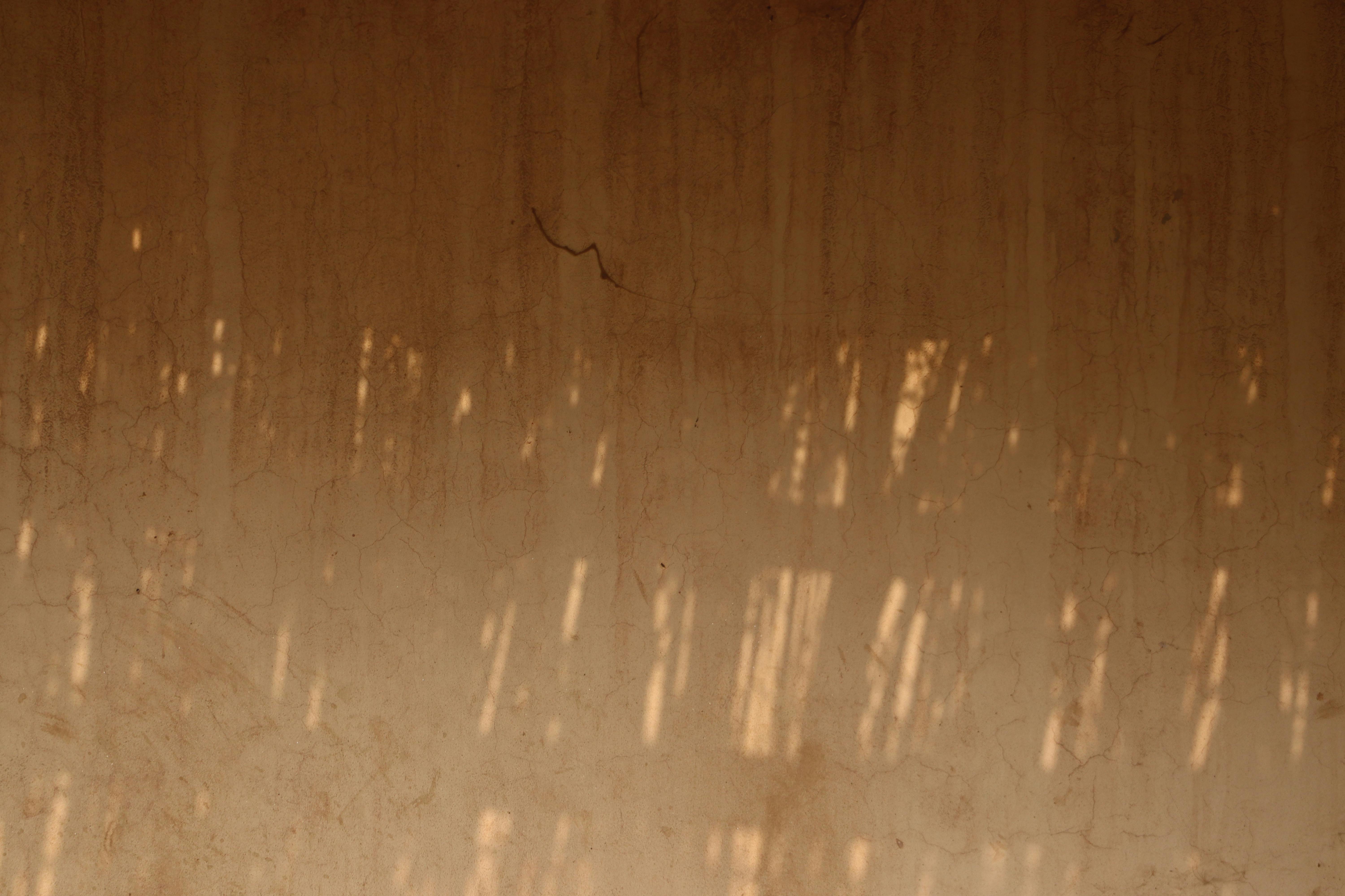 Kostenlos Eine rustikale Wand wirft weiche, warme Schatten und erzeugt so einen abstrakten und beruhigenden Effekt. Stock-Foto