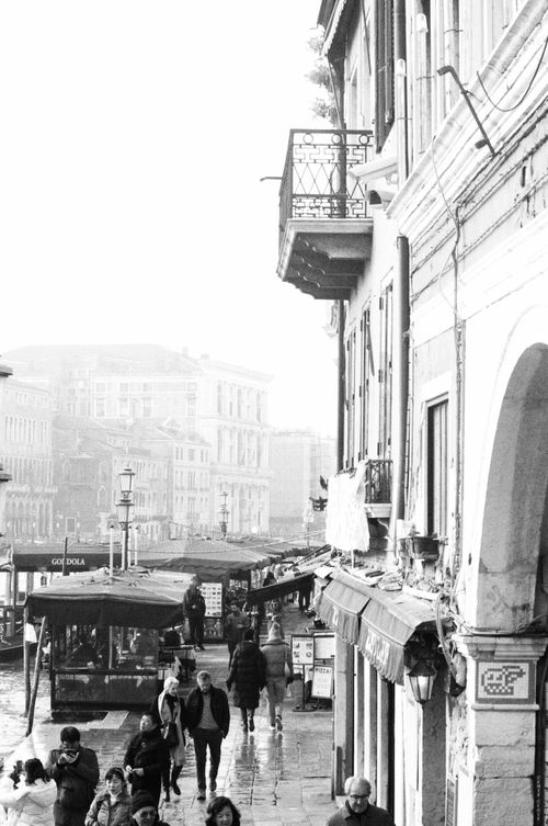 Free A bustling street scene in Venice, capturing architecture and daily life in a vibrant black and white photograph. Stock Photo