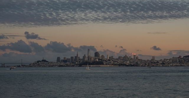 Beautiful view of San Francisco skyline with tranquil waters and a dramatic sunset sky.