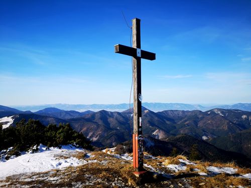 Free A wooden cross stands on a snowy mountain summit with breathtaking panoramic views. Stock Photo
