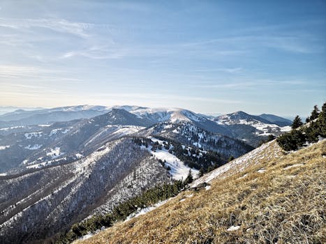 Breathtaking view of snow-capped mountain ranges with a clear blue sky during wintertime.