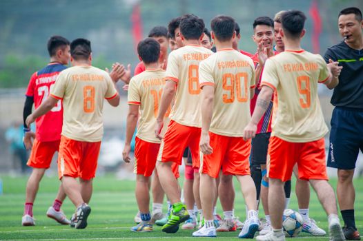Football players in Hanoi greeting teammates on the field.