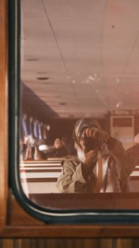 A photographer captures their reflection on a train window, creating an artistic and introspective scene.