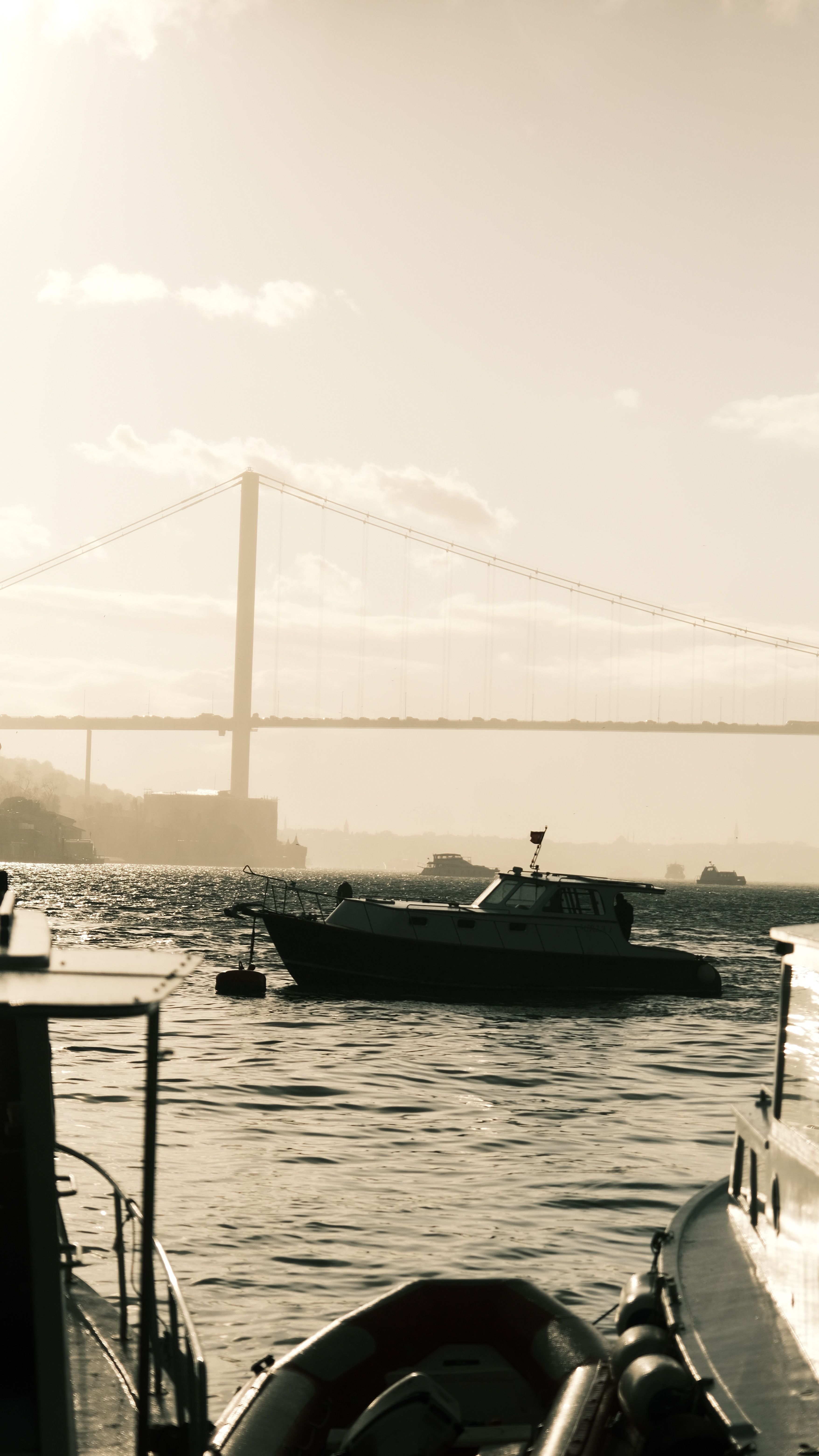 Serene Boat Scene with Bridge in Sepia Tone · Free Stock Photo
