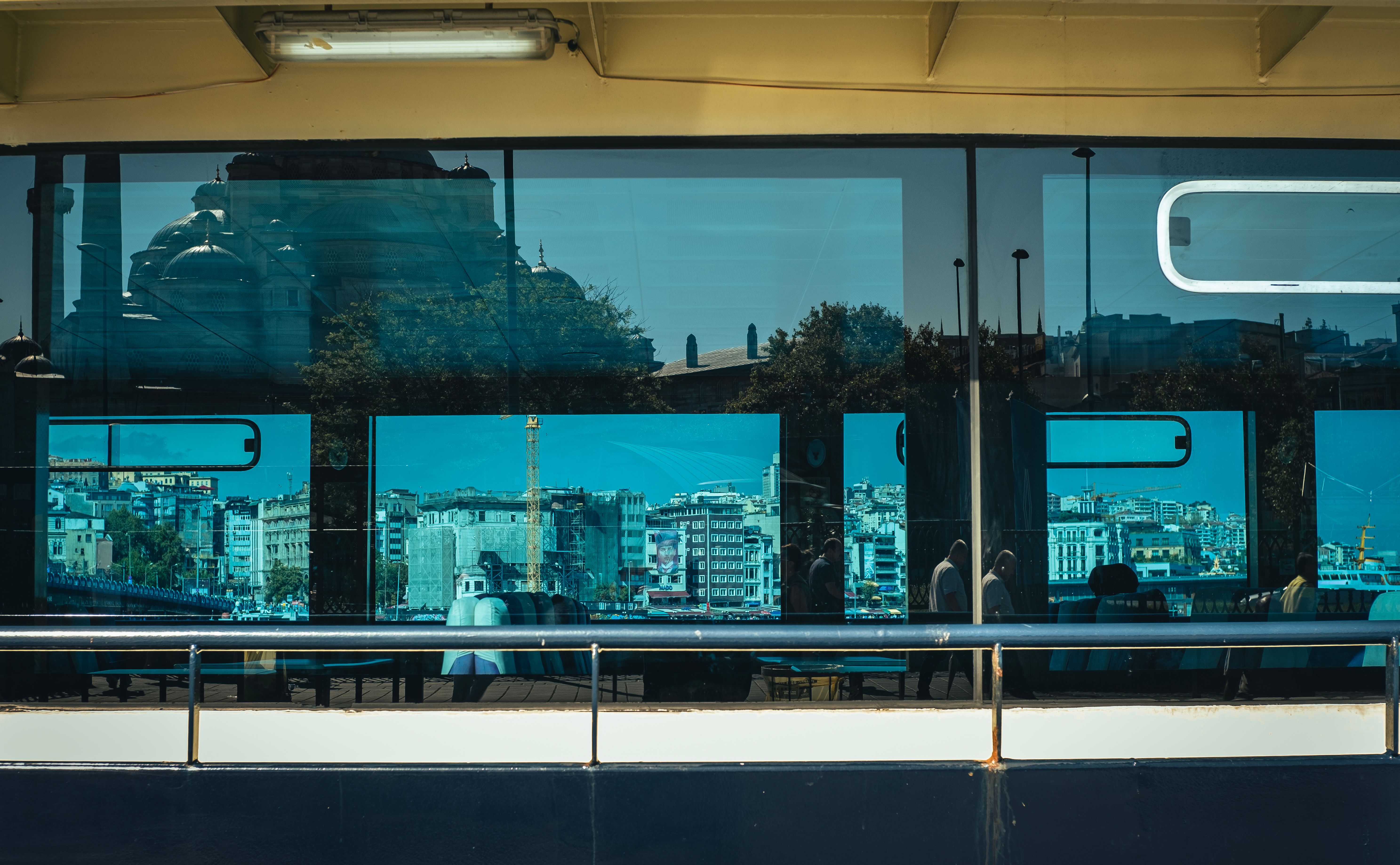 Cityscape reflected in blue-tinted glass, capturing architecture and urban life.