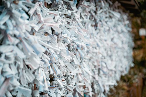 Free Omikuji fortune papers tied in abundance at a Japanese Shinto shrine, symbolizing hopes and prayers. Stock Photo