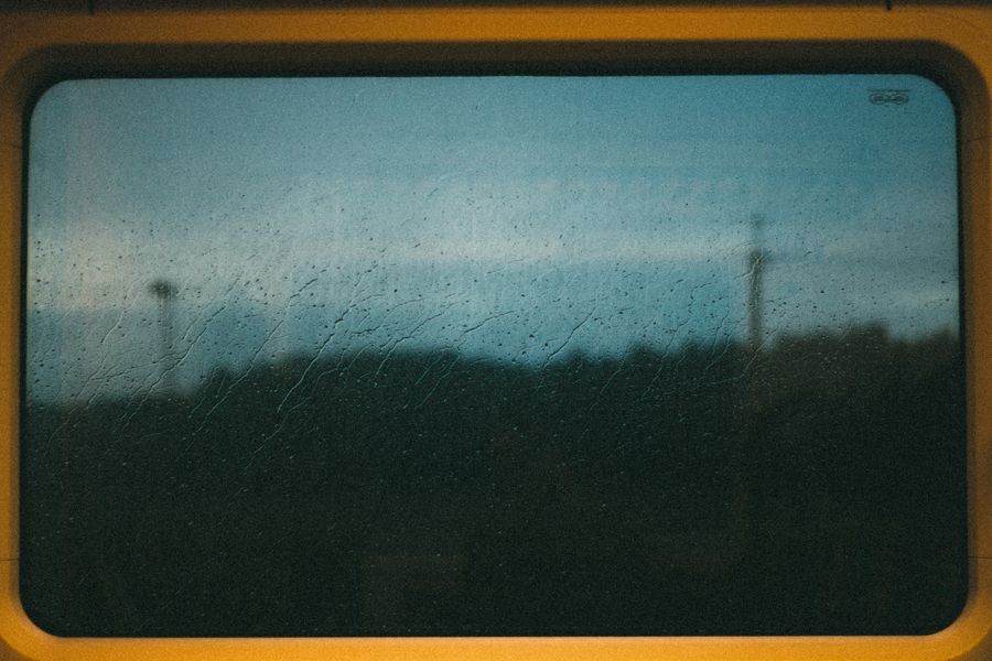 A rainy window view from a train in Tallinn, Estonia, capturing an atmospheric and moody landscape.