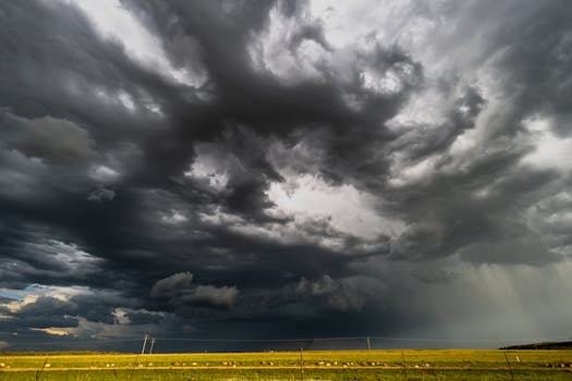 Powerful storm clouds gather over a grassy field in KwaZulu-Natal, South Africa.