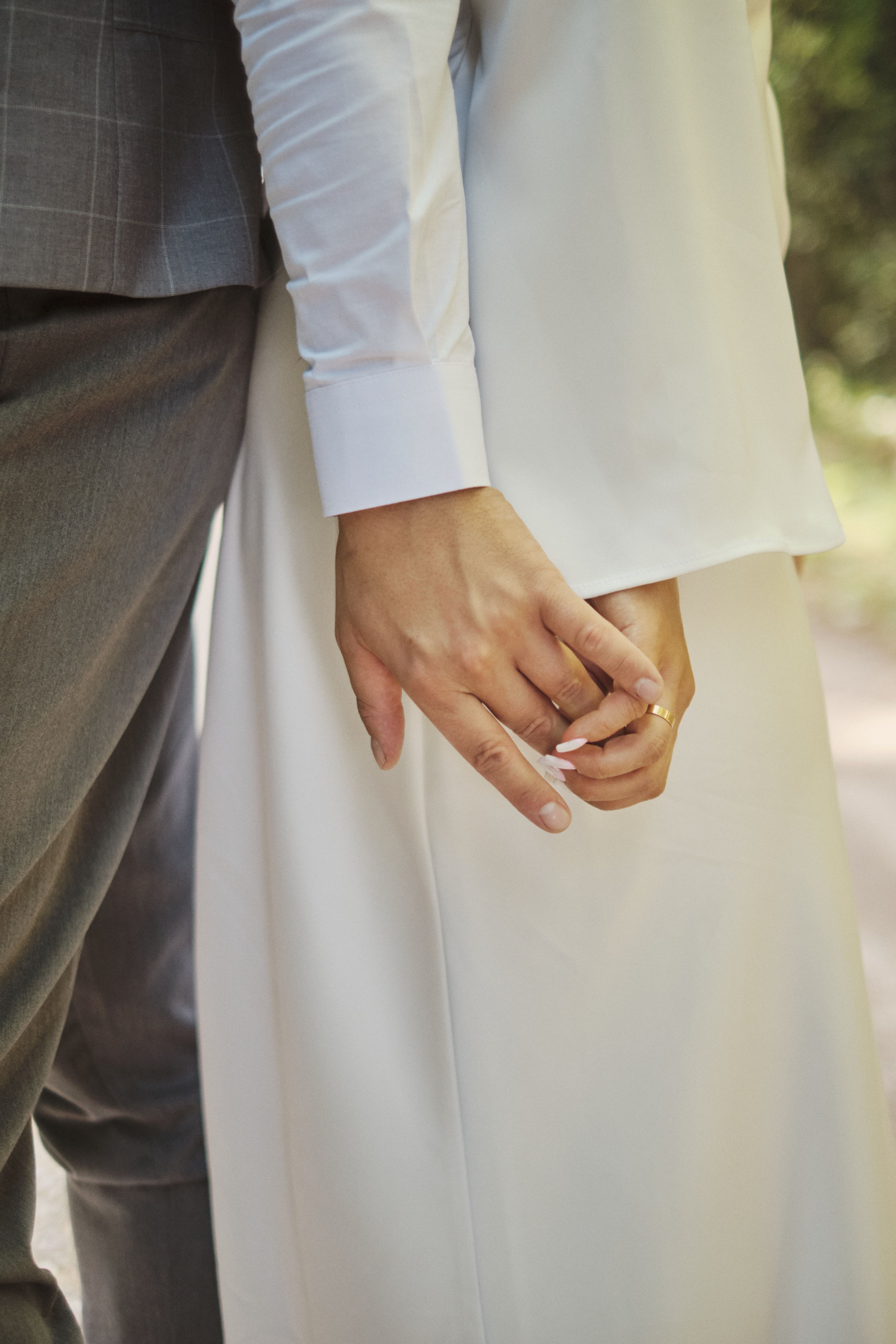 Elegant Wedding Couple Holding Hands Outdoors · Free Stock Photo