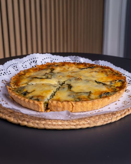 Free Freshly baked spinach quiche with a golden cheese topping, ready to serve. Stock Photo