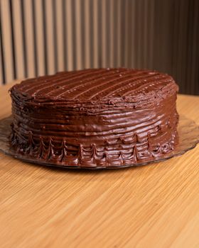 Rich chocolate cake with creamy frosting on a wooden table