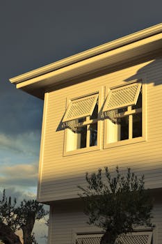 Sunset light casts shadows on a traditional wooden house in Istanbul, Türkiye.