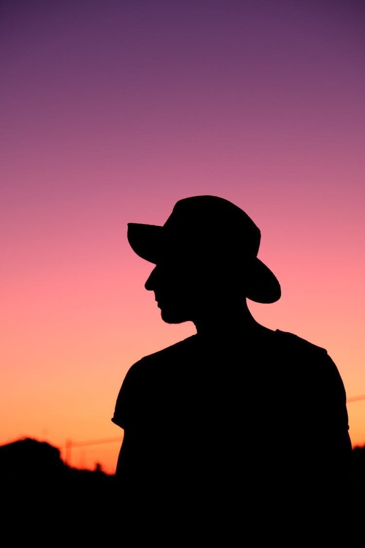 Silhouette Photo Of Person Wearing Hat