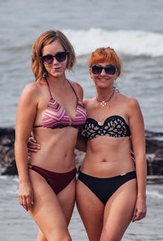 Two women enjoying a sunny day at Anjuna Beach in Goa, India.