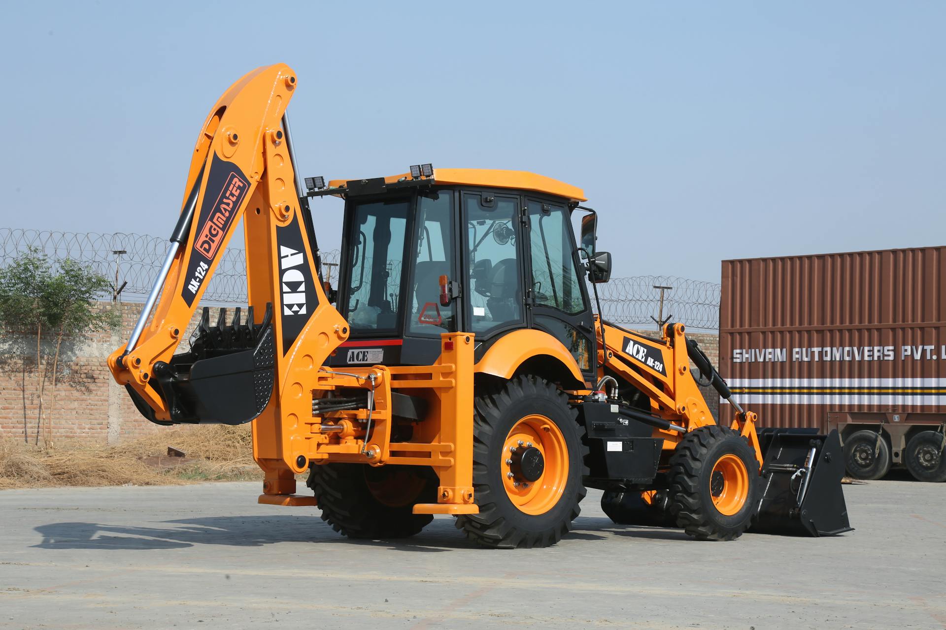 ACE AX 124 backhoe loader on a sunny day at Faridabad construction site.