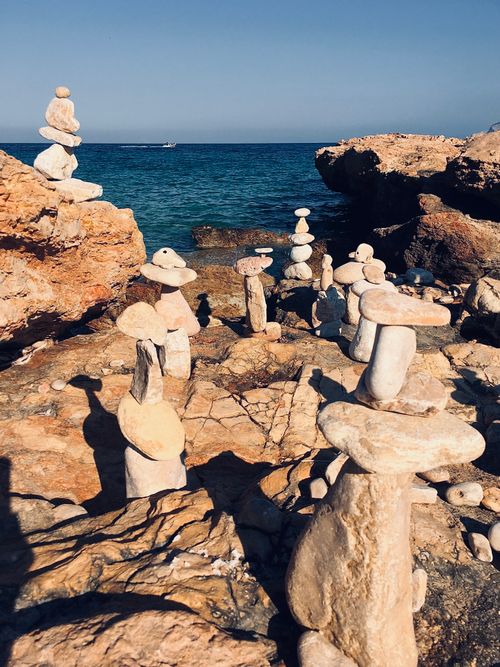 Free Intricate rock piles set against the blue waters of the Aegean Sea in the afternoon sun. Stock Photo