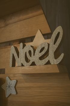 Elegant Noel decoration on a rustic wooden shelf with a festive holiday atmosphere.