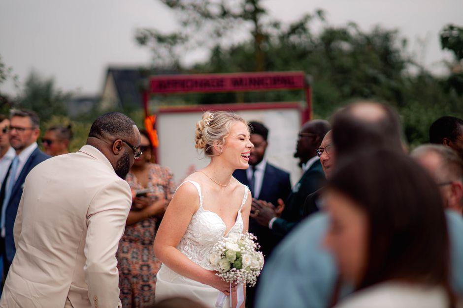 bride and groom laughing with guests during celebration