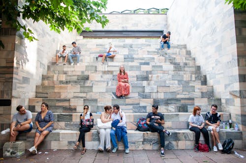 Free People Sitting on Benches Near Park Stock Photo