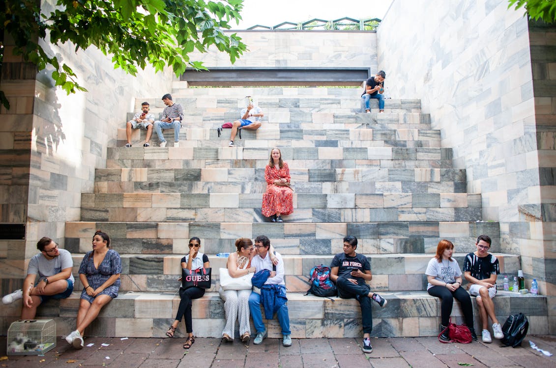 Personas Sentadas En Bancos Cerca Del Parque