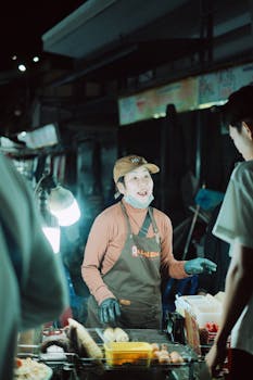Street vendor serving food at night market stall, capturing vibrant nightlife.