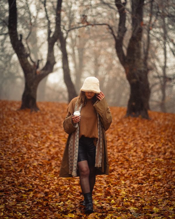 Woman wearing a brown sweater with a plaid scarf and boots