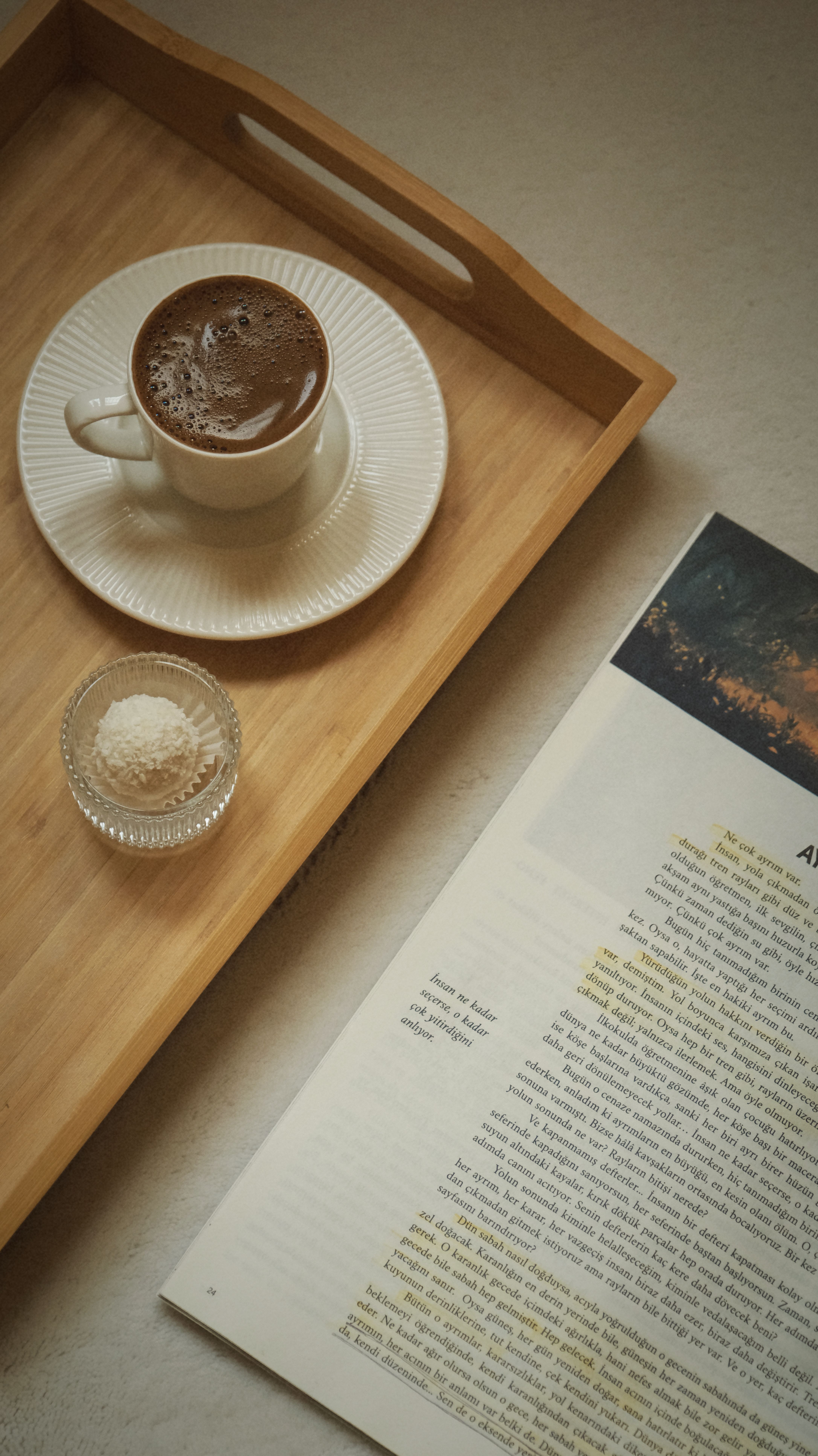 A peaceful morning setup with coffee and an open book on a tray, perfect for relaxation.