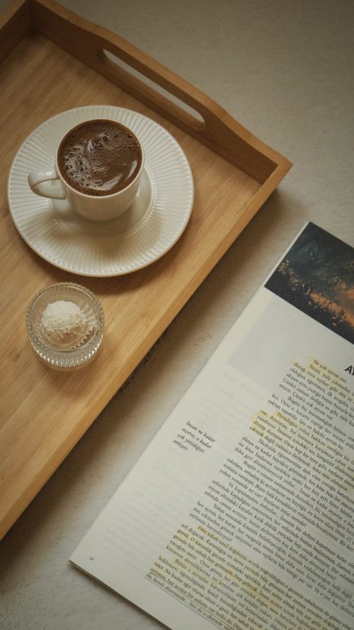 Free A peaceful morning setup with coffee and an open book on a tray, perfect for relaxation. Stock Photo