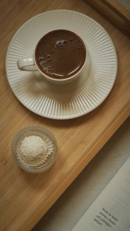 Free A warm cup of coffee with dessert on a tray, perfect for a relaxing read. Stock Photo