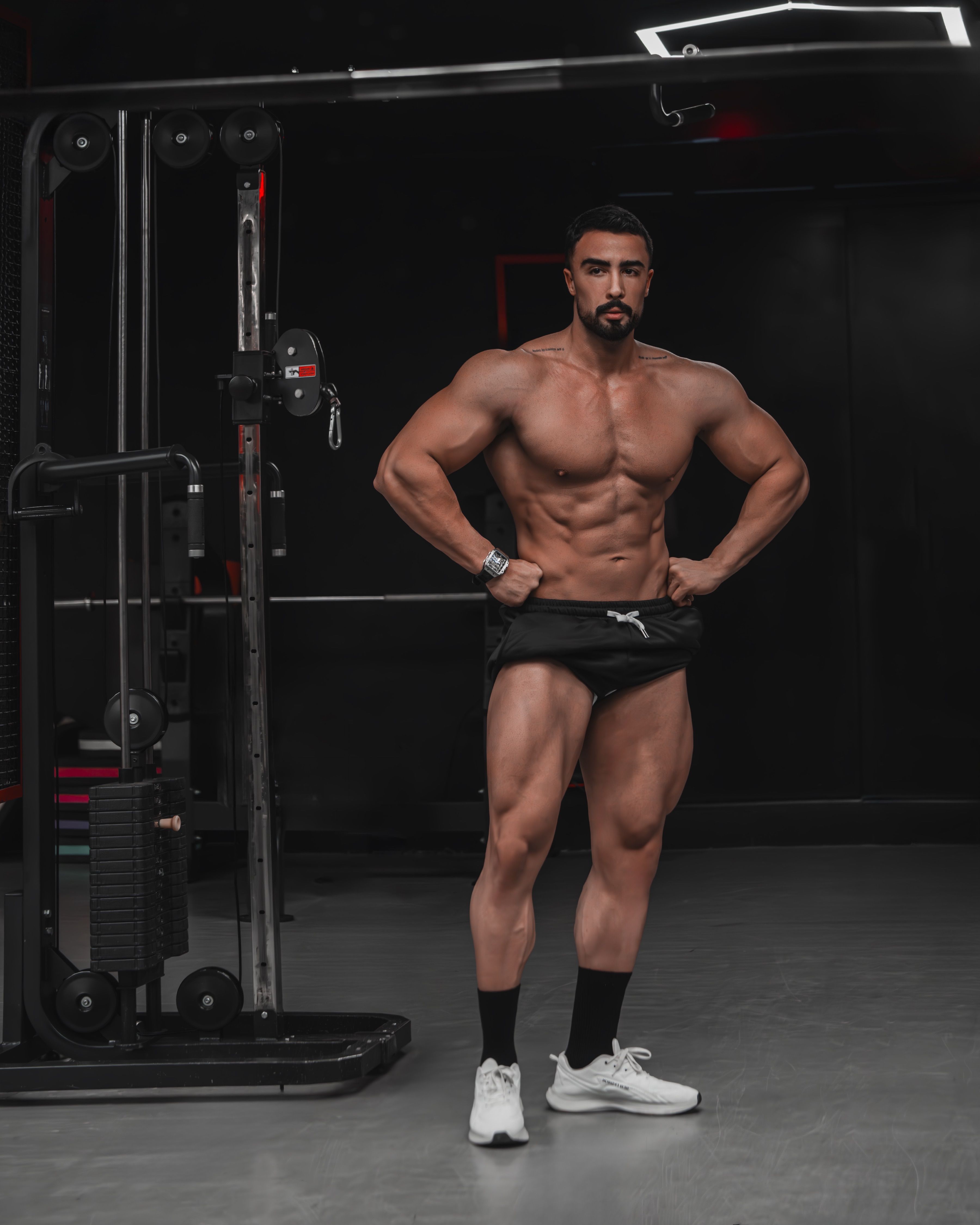 Athletic male posing in a gym showcasing muscle definition and fitness.