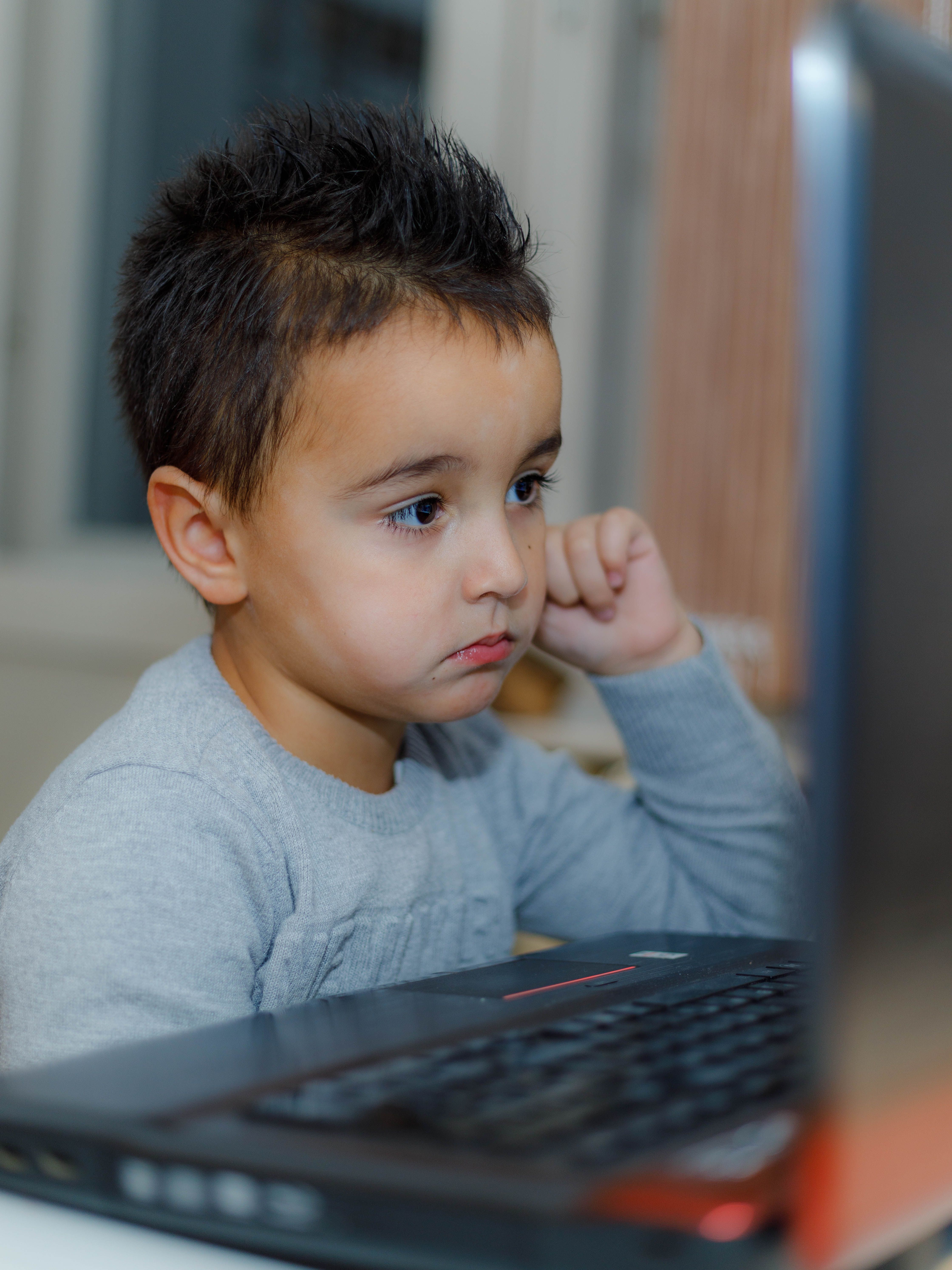 Young boy intently using a laptop, showcasing digital learning and concentration.