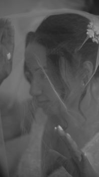 Elegant black and white portrait of a bride gracefully framed by her veil.