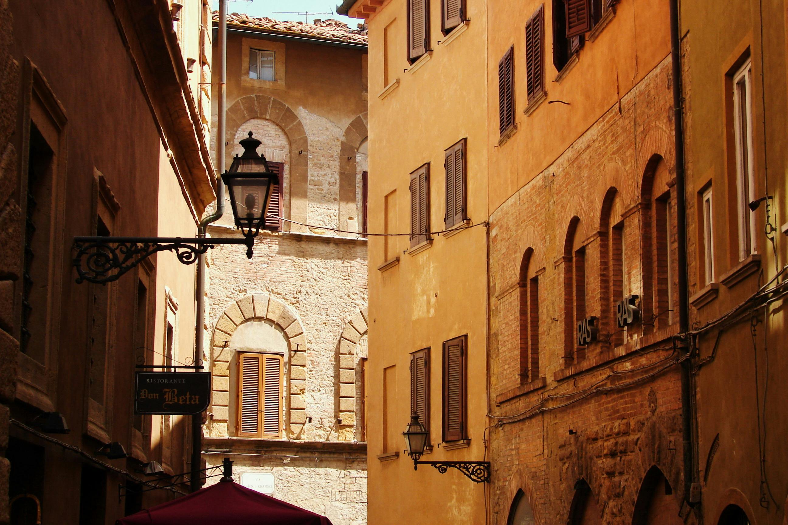 Explore the warm hues and historic architecture of a picturesque alleyway in Volterra, Tuscany.