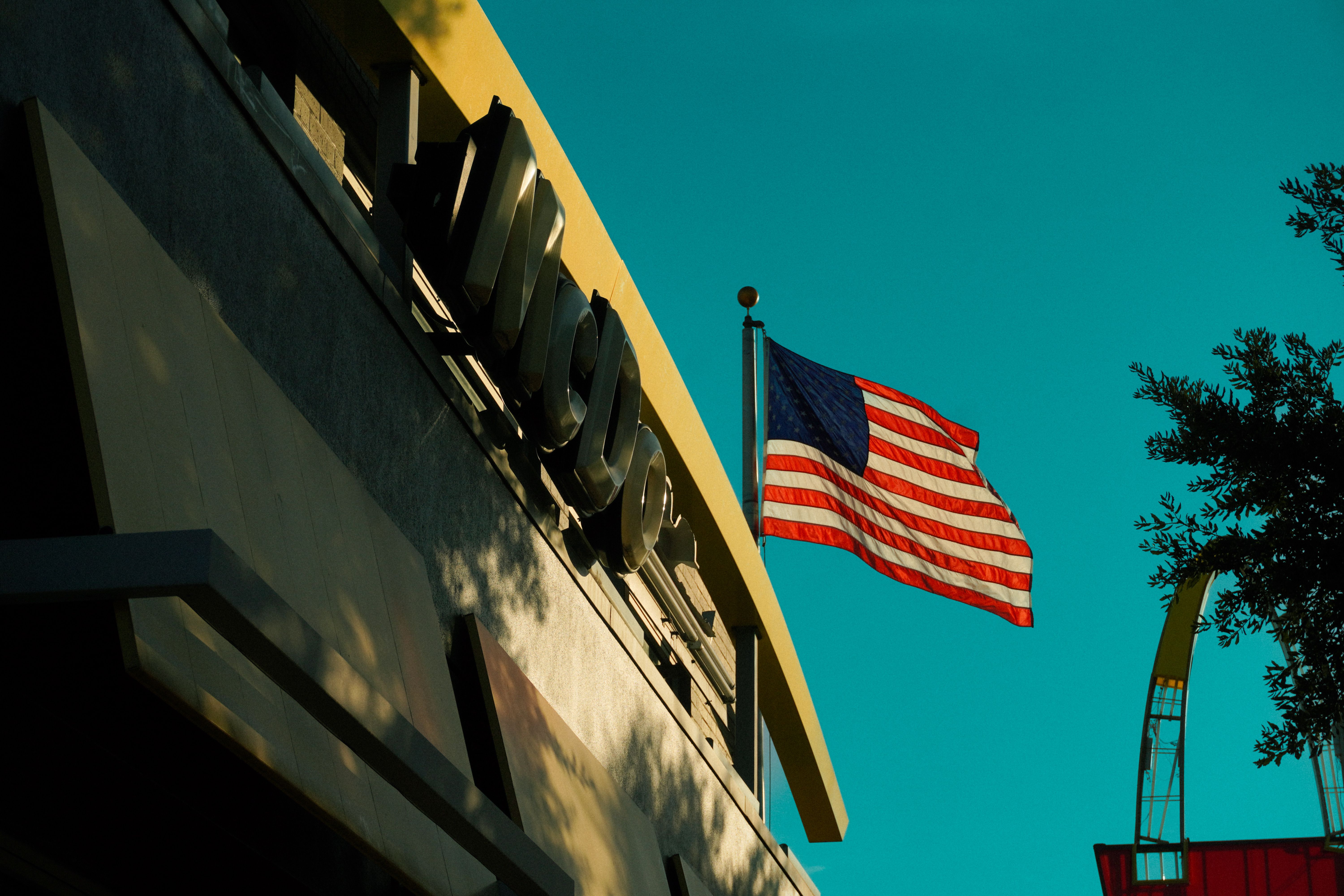 American flag waving beside a McDonald's sign in Houston, Texas during fall.