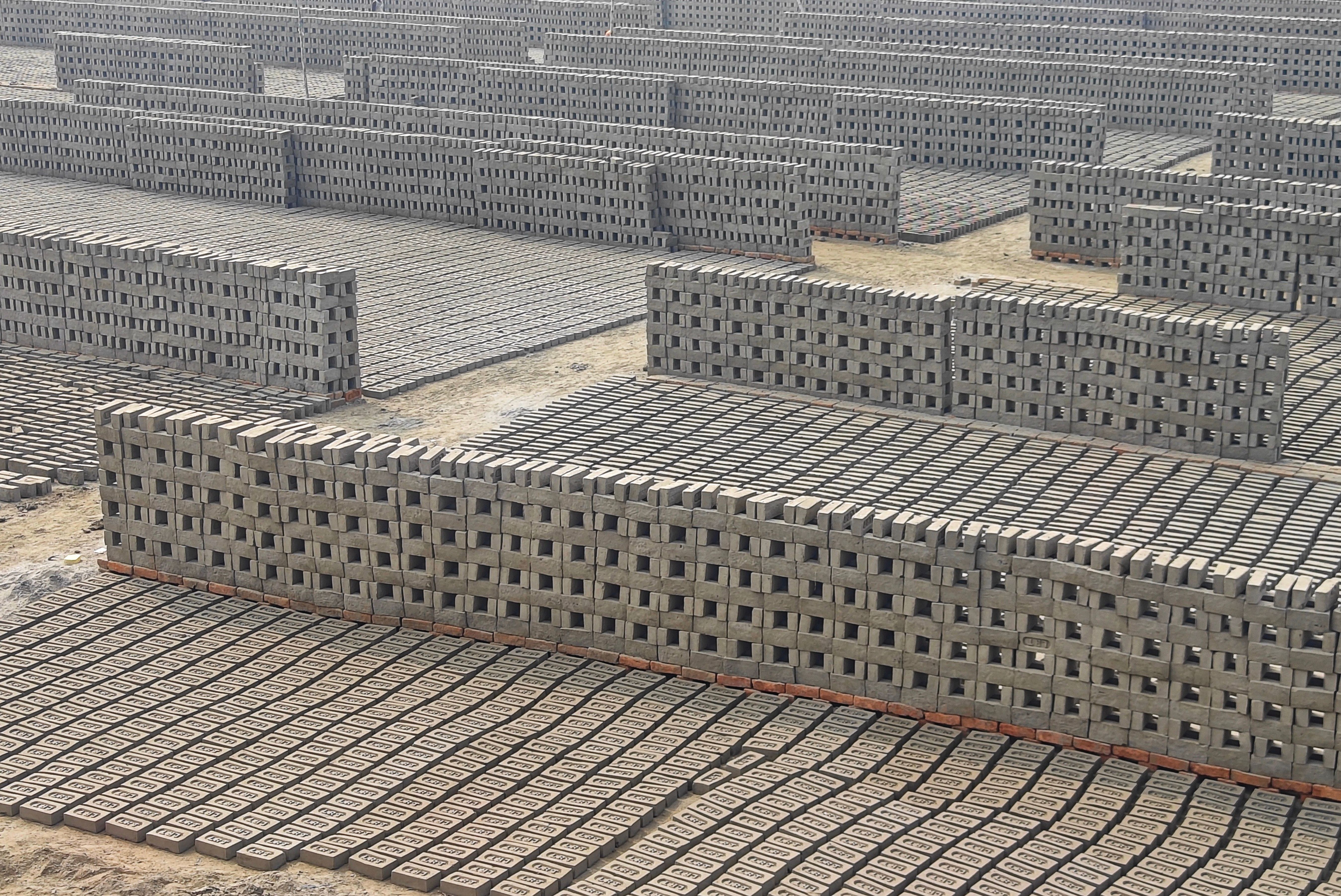 Rows of bricks drying in the sun at an outdoor brick kiln site in Haroa, West Bengal, India.