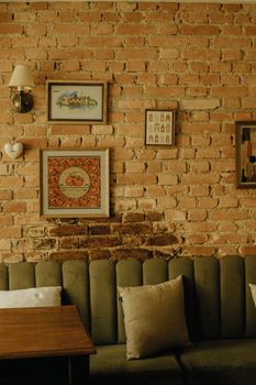 Warm and inviting vintage cafe interior with brick wall and framed art.