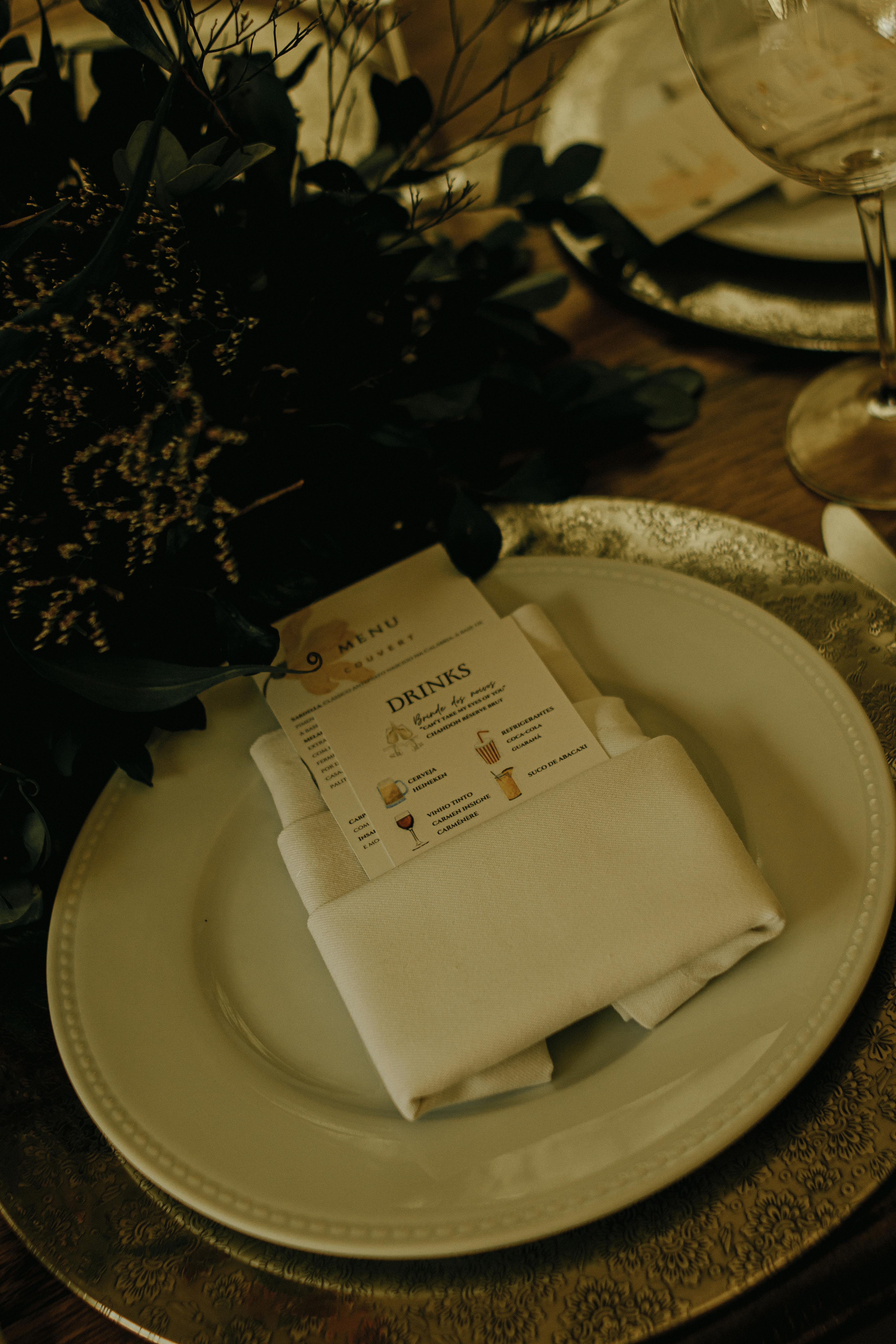 A sophisticated dining setup featuring a menu card on a white plate with elegant decor.