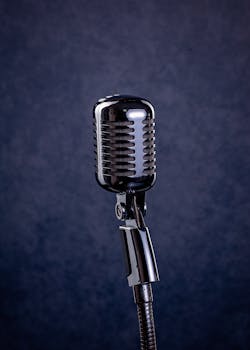 A shiny retro chrome microphone set against a dark studio backdrop, evoking classic broadcast style.