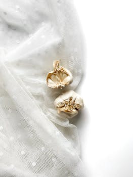 Minimalist composition of garlic bulbs on a dotted white fabric background.