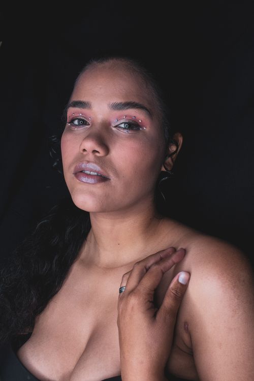 Free Close-up portrait of a woman with creative eye makeup and soft lighting, conveying elegance and poise. Stock Photo