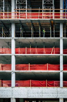 High-rise construction site with a worker on scaffolding in Boise, Idaho.