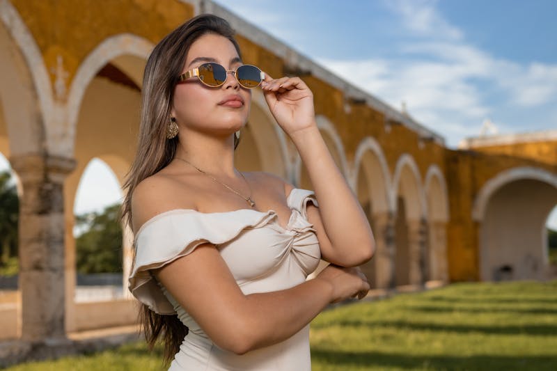 Femme élégante en robe avec des lunettes de soleil dans un site historique