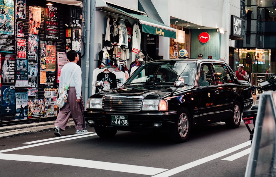 Vibrant street scene in downtown Osaka featuring a taxi and diverse storefronts.