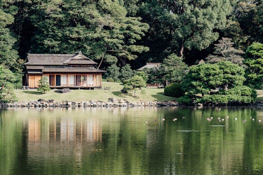Serene Japanese garden scene with a traditional wooden structure by a reflective pond.