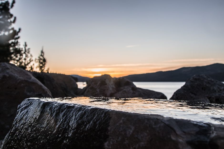 Experience the serene sunset over Lake Tahoe's rocky shoreline, capturing nature's beauty in Truckee, CA.