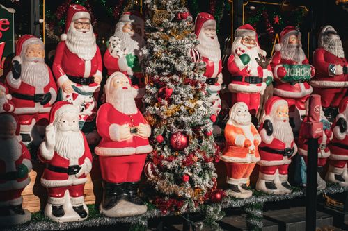 Free Colorful display of Santa Claus statues and a Christmas tree at a holiday shop. Stock Photo