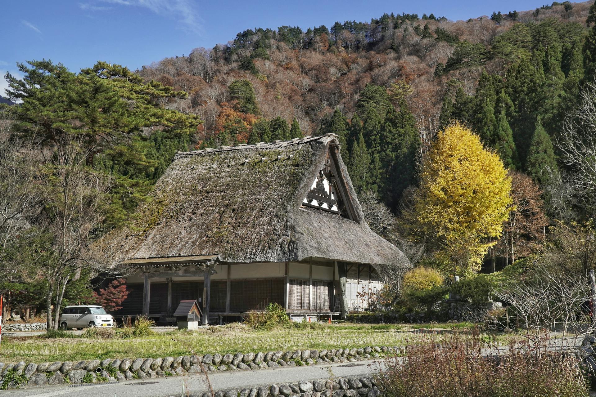 Scenic view of a gassho-style house in a Japanese village during fall.
