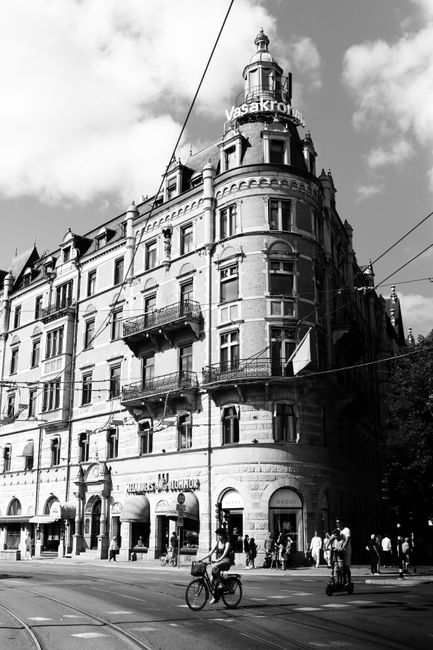 Black and white photo of iconic Stockholm architecture with urban life.