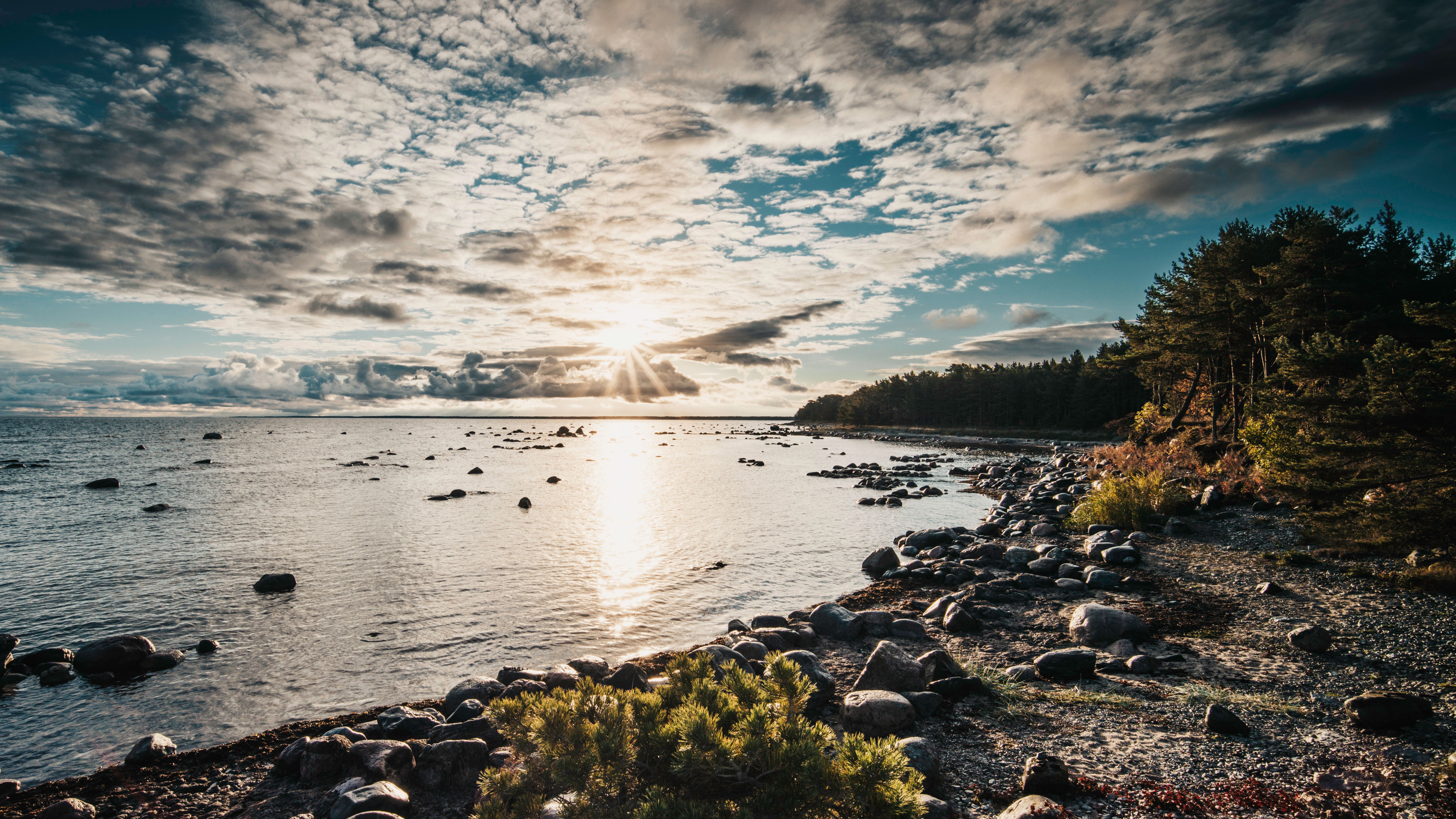 Serene Beach Sunrise at Rocky Shoreline · Free Stock Photo
